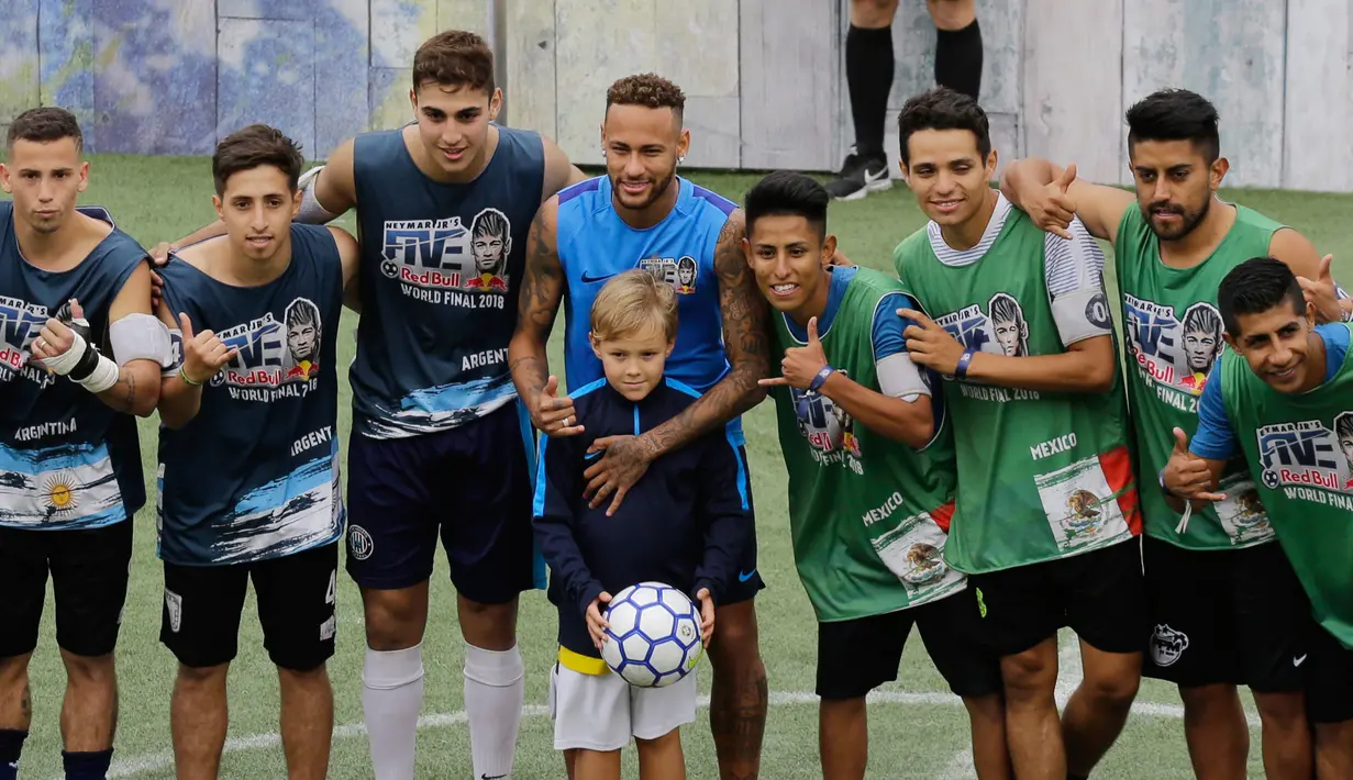 Bintang sepak bola Brasil, Neymar (tengah) dan putranya Davi Lucca foto bersama pemain Argentina (kiri) dan Meksiko saat turnamen untuk badan amal Neymar Junior Project Institute di Praia Grande, Sao Paulo, Brasil, Sabtu (21/7). (AP Photo/Nelson Antoine)
