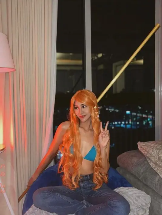 Anya Geraldine tampil dengan bikini biru, high waist pants, dan rambut oranye khas Nami dari serial One Piece.