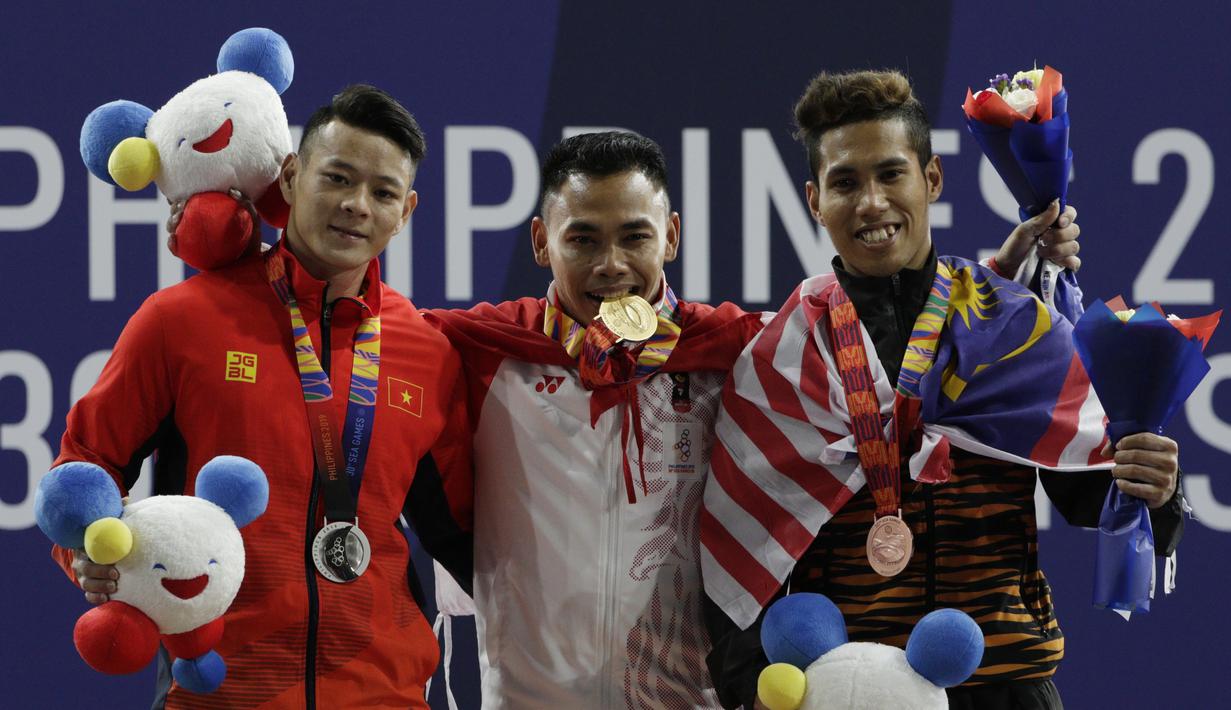 Lifter Eko Yuli (tengah) melakukan selebrasi saat mendapatkan medali emas SEA Games 2019 cabang angkat besi nomor 61 kg di Stadion Rizal Memorial, Manila, Minggu (1/12). Dirinya meraih emas dengan total angkatan 309 kg. (Bola.com/M Iqbal Ichsan)