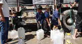 Anak-anak Palestina mengisi wadah mereka dengan air di kamp Nuseirat untuk para pengungsi di Jalur Gaza tengah pada 24 Mei 2025. (Eyad BABA/AFP)