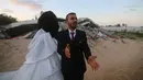 Mohammed Zourab (kanan) bersama pengantin perempuannya menggelar pernikahan di atas reruntuhan rumahnya di Kota Khan Younis, Jalur Gaza, 1 Maret 2020. Upacara pernikahan warga Palestina digelar di atas reruntuhan salah satu rumah yang hancur akibat serangan jet Israel. (Xinhua/Khaled Omar)