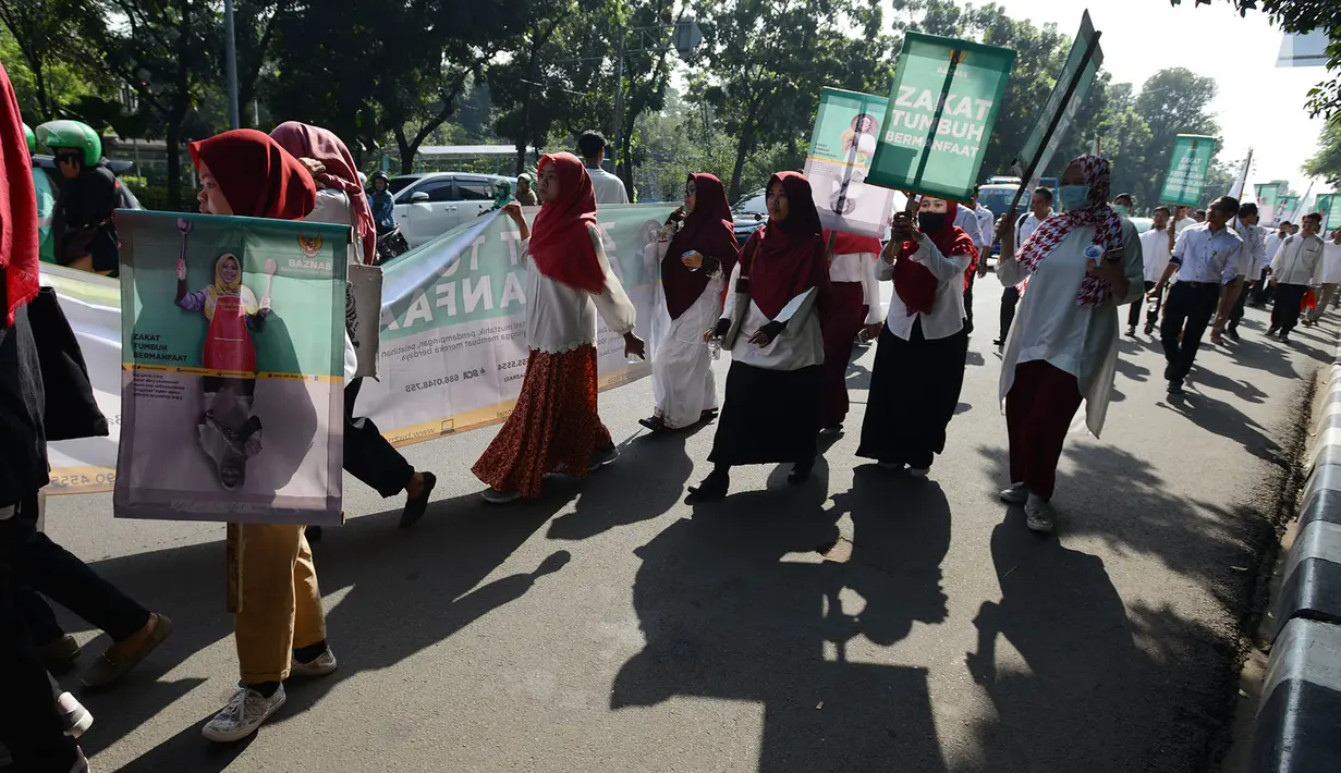 Badan Amil Zakat Nasional (Baznas) melakukan pawai simpatik menyambut Ramadan 1440 Hijriah di Patung Kuda, Jakarta, Jumat (3/5/2019). Dalam aksinya, Baznas menyerukan kewajiban membayar zakat, mengingat Ramadan semakin dekat. (merdeka.com/Imam Buhori)
