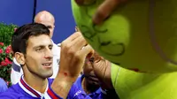 Novak Djokovic memberikan tanda tangan kepada fansnya seusai menjuarai AS Terbuka 2015, Senin (14/9/2015) pagi WIB.  (Reuters/Lucas Jackson)