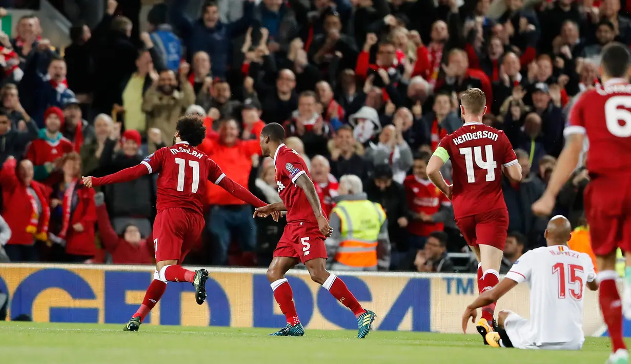 Gelandang Liverpool, Mohamed Salah bersama rekan setimnya berselebrasi setelah membobol gawang Sevilla dalam laga Grup E Liga Champions di Stadion Anfield, Rabu (13/9). Sevilla berhasil menahan imbang Liverpool dengan skor 2-2. (AP Photo/Frank Augstein)