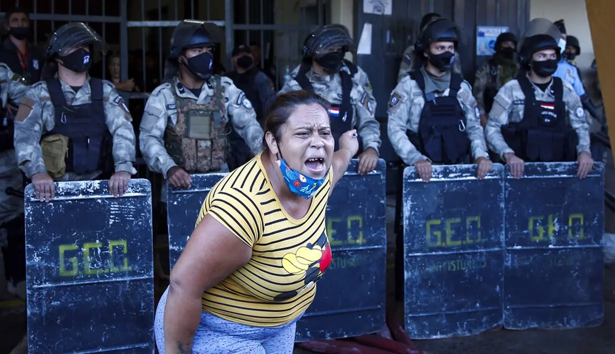 Kerabat narapidana memprotes polisi usai kerusuhan di penjara Tacumbu, Asuncion, Paraguay, Selasa (16/2/2021). Menurut Kementerian Kehakiman Paraguay, enam narapidana tewas dalam kerusuhan di penjara Tacumbu. (AP Photo/Jorge Saenz)