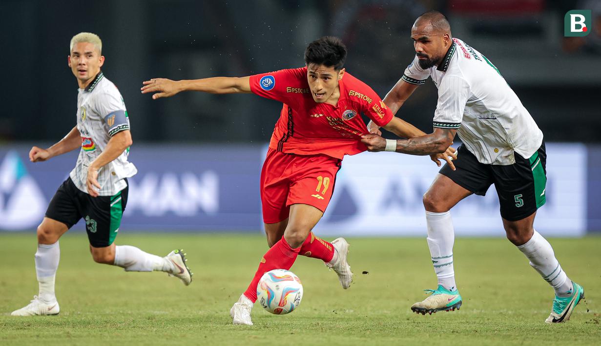 Gelandang Persija Jakarta, Hansamu Yama (tengah), berusaha melewati hadangan pemain PSS Sleman, Thales (kanan) dalam pertandingan pekan ke-23 BRI Liga 1 2023/2024 di Stadion Patriot Chandra Bhaga, Bekasi, Sabtu (16/12/2023). (Bola.com/Bagaskara Lazuardi)