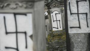 Sejumlah batu nisan dan monumen Holocaust yang dicoret-coret dengan simbol swastika nazi di sebuah pemakaman Yahudi di Strasbourg, Prancis (17/12). Aksi vandalisme ini diketahui dilakukan Selasa di pemakaman Yahudi Herrlisheim. (AFP Photo/Sebastien Bozon)
