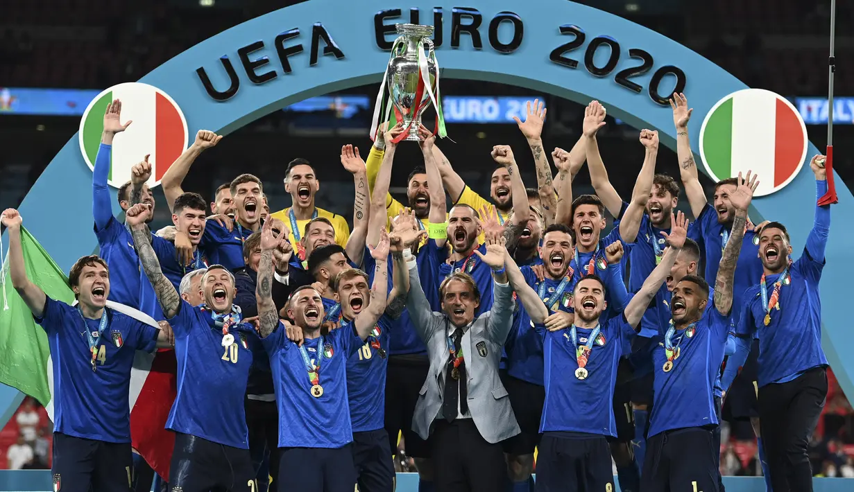 Para pemain Italia mengangkat trofi juara Euro 2020 usai mengalahkan Inggris pada pertandingan final di Stadion Wembley, London, Inggris, Minggu (11/7/2021). Italia menang 3-2 lewat adu penalti usai bermain imbang 1-1 di waktu normal. (Michael Regan/Pool via AP)