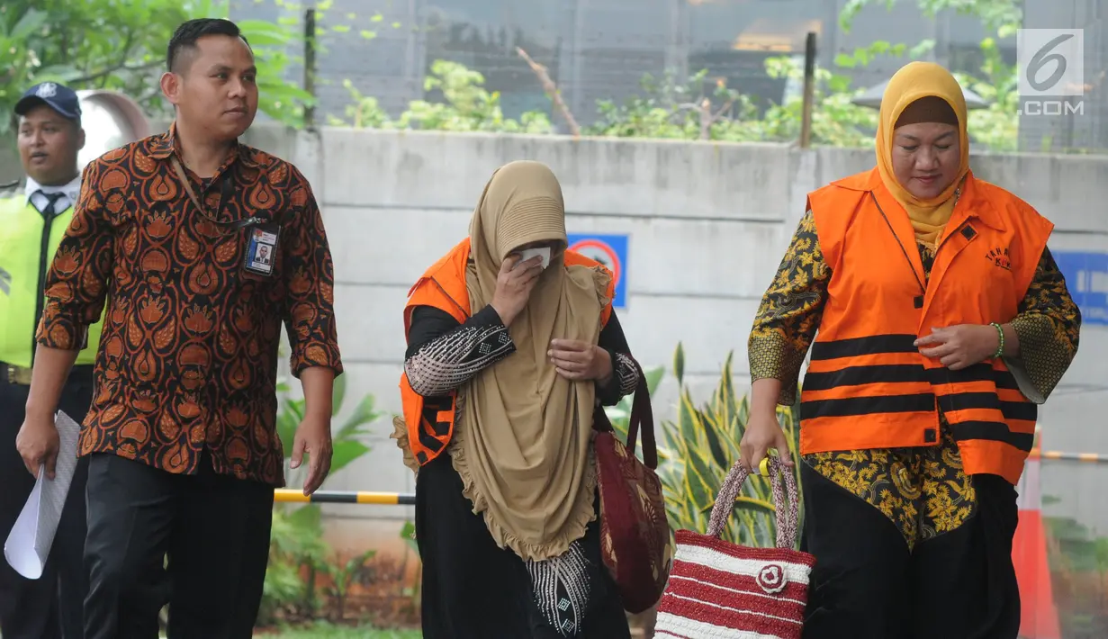 Tersangka Anggota DPRD Kota Malang Asia Iriani (kanan) dan Een Ambarsari (tengah) tiba di Gedung KPK, Jakarta, Rabu (21/11). Keduanya banyak menunduk saat tiba di Gedung KPK. (Merdeka.com/Dwi Narwoko)