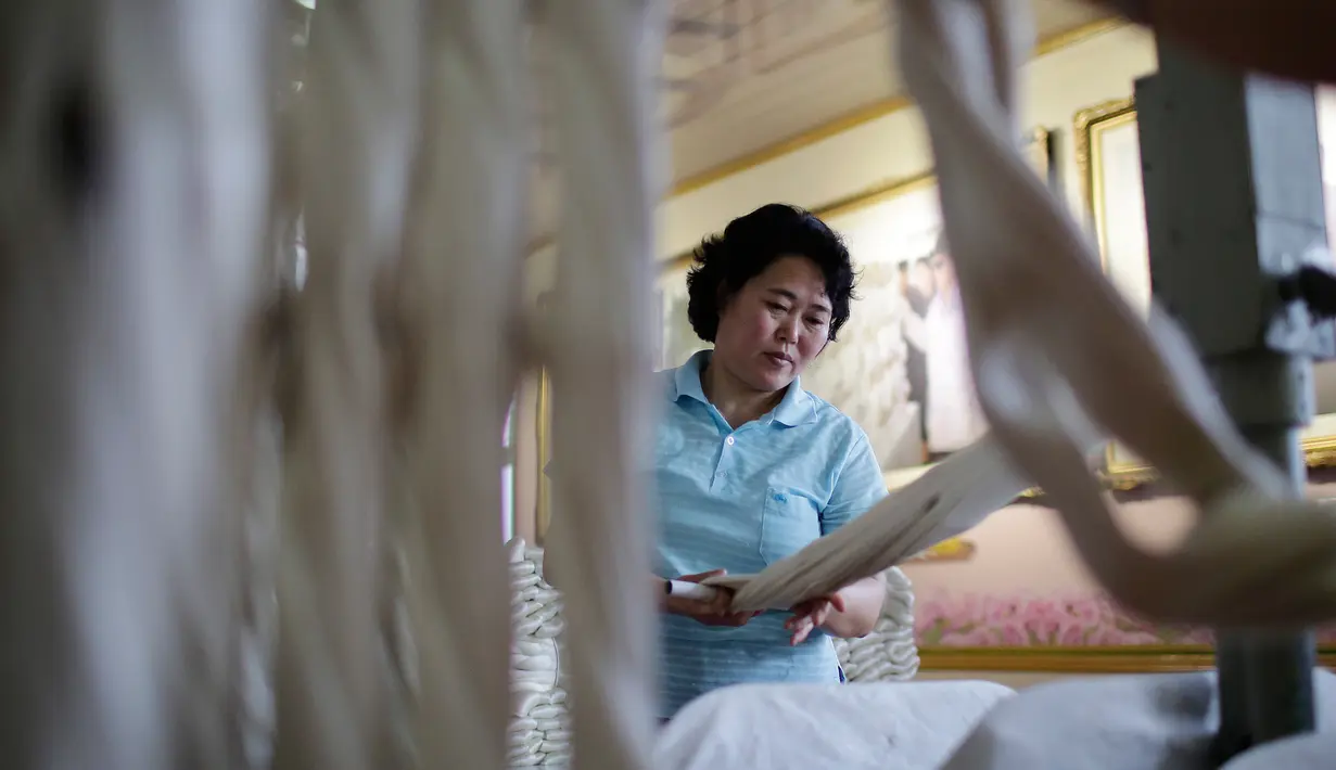 Seorang pekerja wanita menyelesaikan pekerjaannya di Kim Jong Suk Silk Mill, Pyongyang, Korea Utara (6/1). Pabrik ini mampu menghasilkan benang sutra sebanyak 200 ton. (AP Photo/Wong Maye-E)