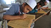 Beberapa santri memaknai Kitab Kuning saat mengaji 'Kilatan Kitab' di Pondok Pesantren Almiizan, Kabupaten Bogor, Senin (21/5). Ngaji kitab kuning ini merupakan tradisi di pondok pesantren pada saat bulan Ramadan. (Merdeka.com/Arie Basuki)