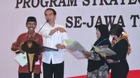Jokowi menyerahkan sertifikat hak atas tanah program strategis nasional di Gedung New Sari Utama Convention Hall, Jember. (Biro