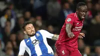 Winger Liverpool, Sadio Mane berebut bola dnegan bek FC Porto, Alex Telles pada leg kedua perempat final Liga Champions 2018/2019 di Estadio do Dragao, Rabu (17/4). Liverpool memastikan lolos ke babak semifinal Liga Champions setelah membantai FC Porto 4-1. (AP Photo/Luis Vieira)