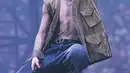 Jimin pamerkan postur tubuhnya dengan atasan rajut lurex perak berlapis vest berwarna khaki. Dipadu dengan celana panjang katun biru tua. Ia juga mengenakan ikat pinggang kulit hitam kepang dan sepasang sepatu kulit hitam. [Dior]