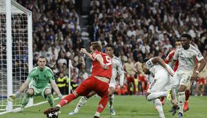 Momen striker Bayern Munchen Harry Kane melakukan shooting ke gawang Real Madrid yang dikawal Andriy Lunin. (Oscar DEL POZO / AFP)