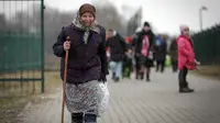 Seorang wanita tua memegang tongkat saat pengungsi, kebanyakan wanita dan anak-anak, tiba di perbatasan di Medyka, Polandia, Sabtu (5/3/2022). Mereka melarikan diri dari invasi Rusia di Ukraina. (AP Photo/Visar Kryeziu)