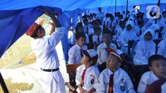 Murid-murid berada di dalam tenda darurat  akibat bangunan atau kelas roboh saat hujan deras  pada hari Rabu (1/1/2020) lalu di SDN Cirimekar 2, Cibinong, Bogor, Senin (6/1/2020). (merdeka.com/Arie Basuki)
