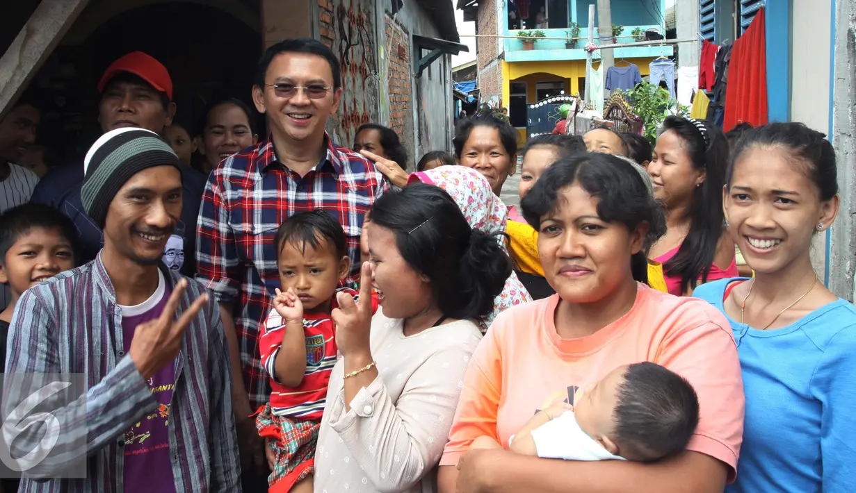 Cagub DKI Jakarta Basuki Tjahaja Purnama atau Ahok berfoto bersama warga saat blusukan di Marunda, Cilincing, Jakarta, Rabu (2/1). Dalam blusukannya Ahok menekankan kepada warga untuk mengurus sertifikat tanah mereka. (Liputan6.com/Gempur M. Surya)