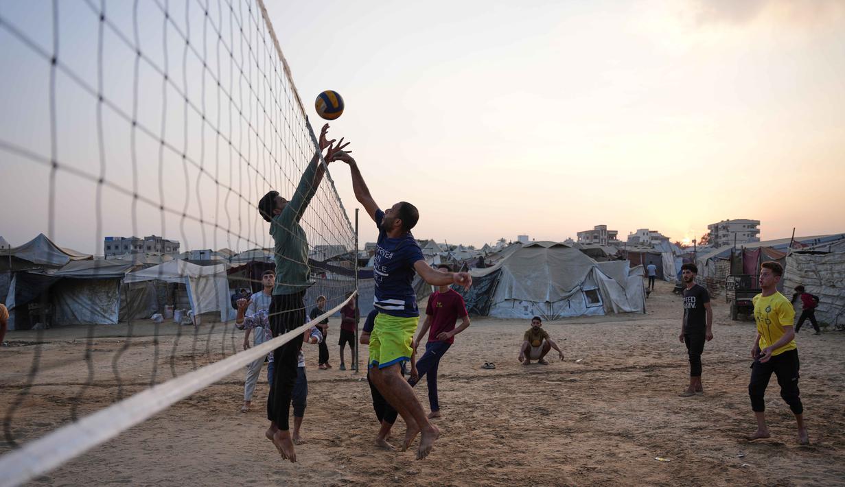 Anak-anak muda Palestina bermain voli di kamp tenda pengungsian di Zawayda, Jalur Gaza tengah, Selasa 4 November 2025. Diketahui, meski kesepakatan gencatan senjata antara Israel dan Hamas yang dimulai pada 10 Oktober 2025 masih berlaku, namun situasi kemanusiaan di Gaza masih memburuk. (AP Photo/Abdel Kareem Hana)