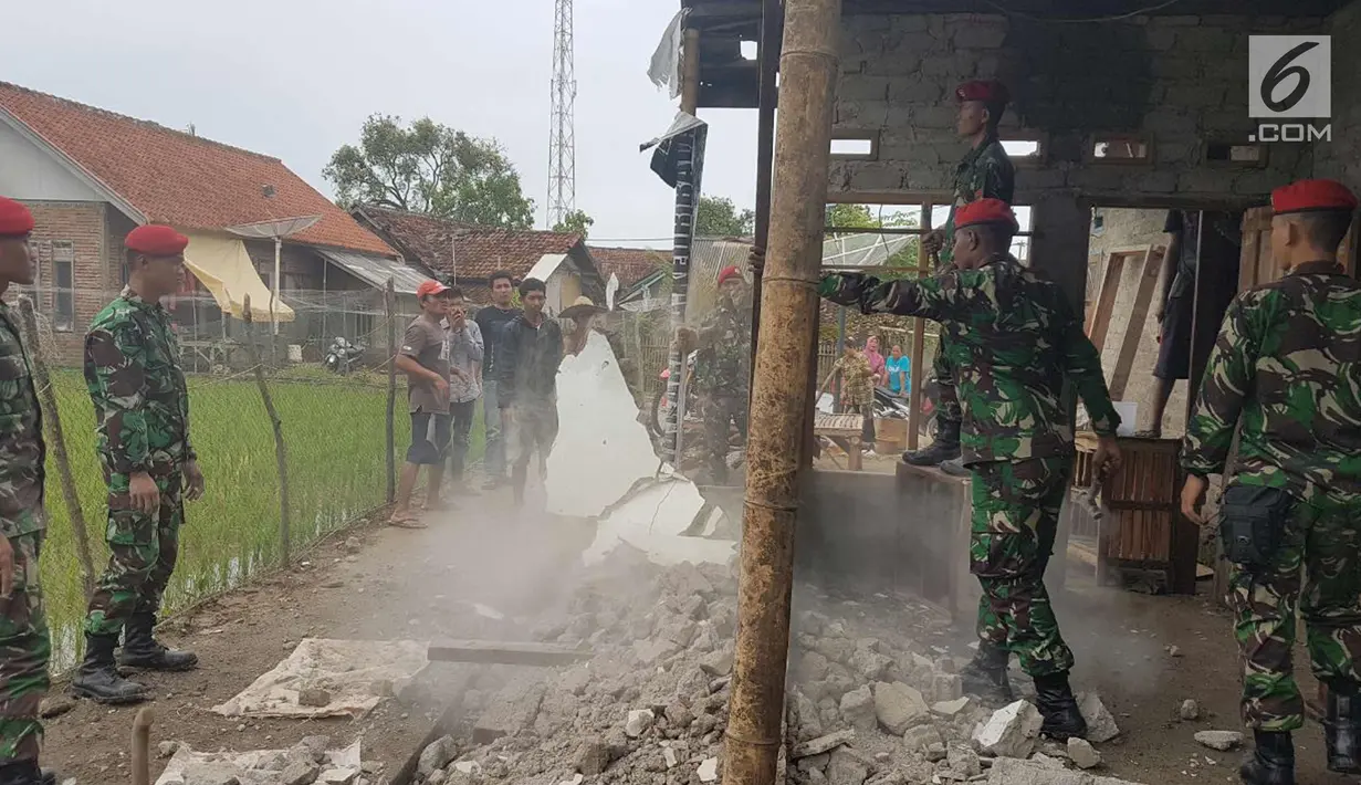 Prajurit Kopassus saat memperbaiki salah satu rumah warga warga terdampak gempa yang mengguncang sejumlah wilayah Jawa Barat dan Banten di Desa Citalahap, Kabupaten Lebak, Bogor (23/1). (LIputan6.com/Pool/Kopassus)
