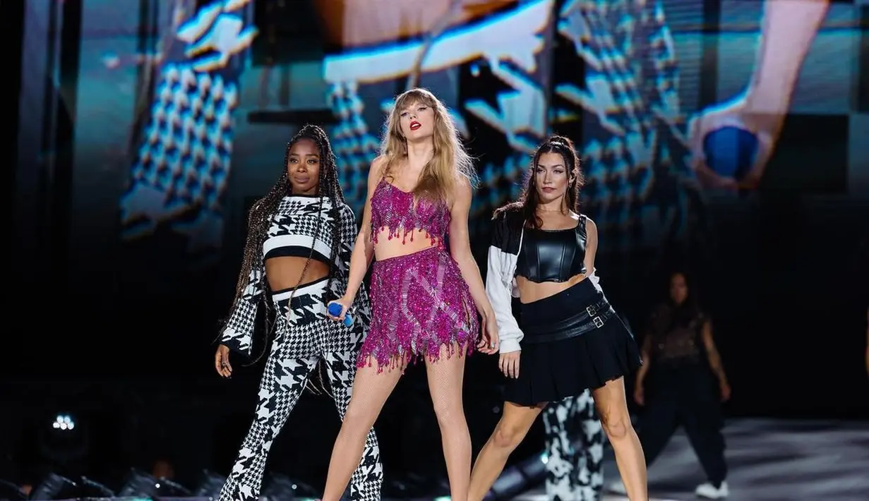 Lagi, aksi panggung memesona Taylor Swift dengan outfit two-pieces berwarna ungu. Outfit berkilauan ini dipadu dengan tatanan rambut yang dibiarkan tergerai dan pulasan lipstik merah. [Foto: Instagram/taylorswift]