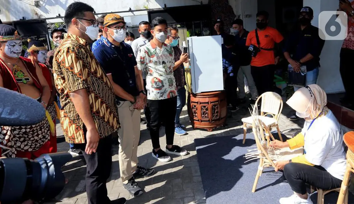 Menteri Parekraf Sandiaga Uno (tengah) dan Walikota Solo Gibran Raka Bumi melihat pembuatan anyaman kursi rotan di Solo, Sabtu (09/10/2021). Keberadaan kesenian wayang tidak terpaku pada pementasan, tetapi pembuatan wayang yang bisa mengundang lapangan pekerjaan lainnya. (Liputan6.com/HO/Parekraf)