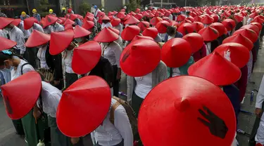 Guru sekolah antikudeta mengenakan seragam dan topi tradisional Myanmar saat berpartisipasi dalam demonstrasi di Mandalay, Myanmar, Rabu (3/3/2021). Demonstran di Myanmar turun ke jalan lagi pada hari Rabu untuk memprotes perebutan kekuasaan bulan lalu oleh militer. (AP Photo)