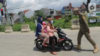 Petugas Satpol PP memberhentikan pengendara motor saat melintasi Pos Pengawasan Larangan Mudik di Cigombong, Bogor, Rabu (29/4/2020). Polres Bogor terus melakukan penyekatan  mencegat pemudik sekaligus PSBB mengantsipasi penyebaran virus Covid-19. (merdeka.com/Arie Basuki)