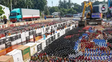 Petugas menggunakan alat berat eskavator saat memusnahkan minuman keras ilegal hasil penindakan di Kantor Pusat Bea Cukai, Jakarta Timur, Rabu (31/7/2024). (merdeka.com/Arie Basuki)