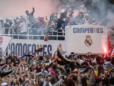 Suporter Real Madrid menyambut timnya saat tiba di Plaza Cibeles, Madrid, Senin (29/5/2016) dalam parade juara Liga Champions. (AFP/Pedro Armestre)
