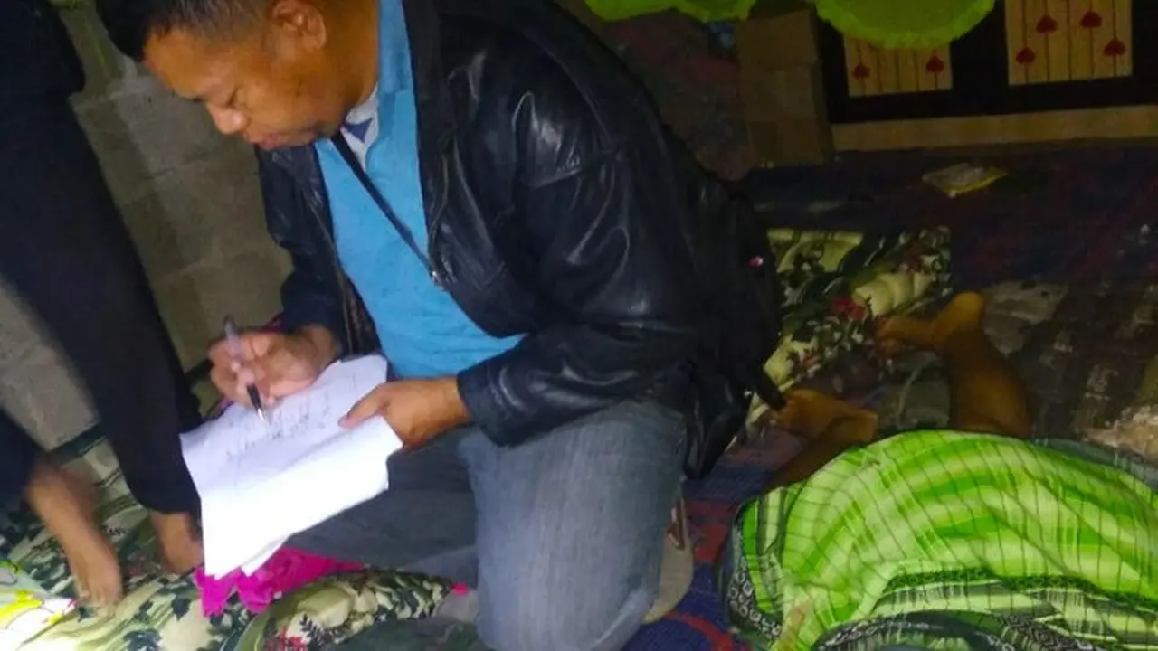 Polisi melakukan olah tempat kejadian perkara di samping jenazah istri yang dibunuh suaminya di Kabupaten Indragiri Hulu, Riau.