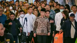 Menteri Luar Negeri, Sugiono (tengah), hadir langsung untuk memantau proses kedatangan serta memastikan kondisi para WNI yang baru tiba. Tampak dalam foto, Menteri Luar Negeri Indonesia, Sugiono (tengah), berjalan bersama Warga Negara Indonesia yang kembali dari Iran tiba di Bandara Internasional Soekarno-Hatta, Tangerang, Banten, pada Selasa 10 Maret 2026. (BAY ISMOYO/AFP)