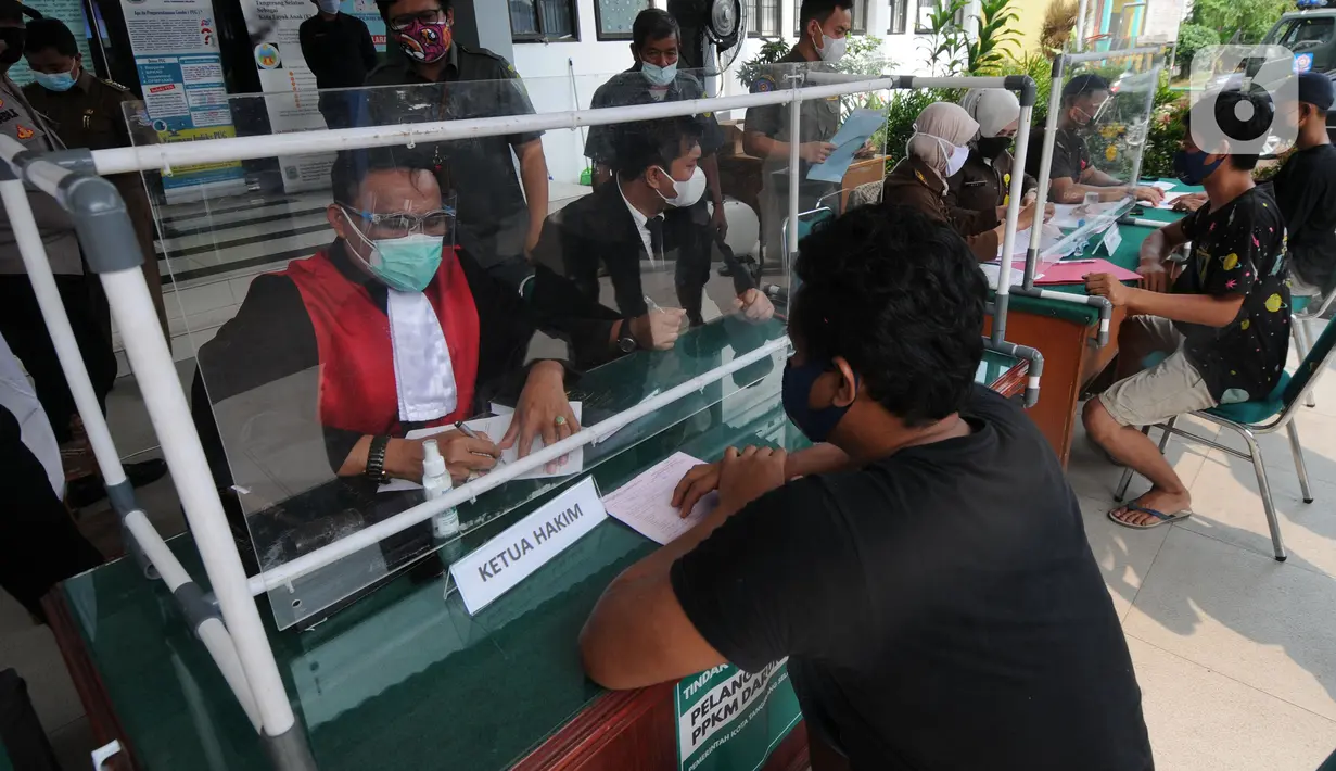 Hakim berbicara kepada pelanggar saat Sidang Tipiring pelanggaran PPKM Darurat di kantor Kecamatan Pamulang, Tangerang Selatan, Banten, Senin (19/7/2021). Dua puluh empat pelanggar diantaranya tidak bermasker dan jam operasional tempat usaha didenda. (merdeka.com/Arie Basuki)