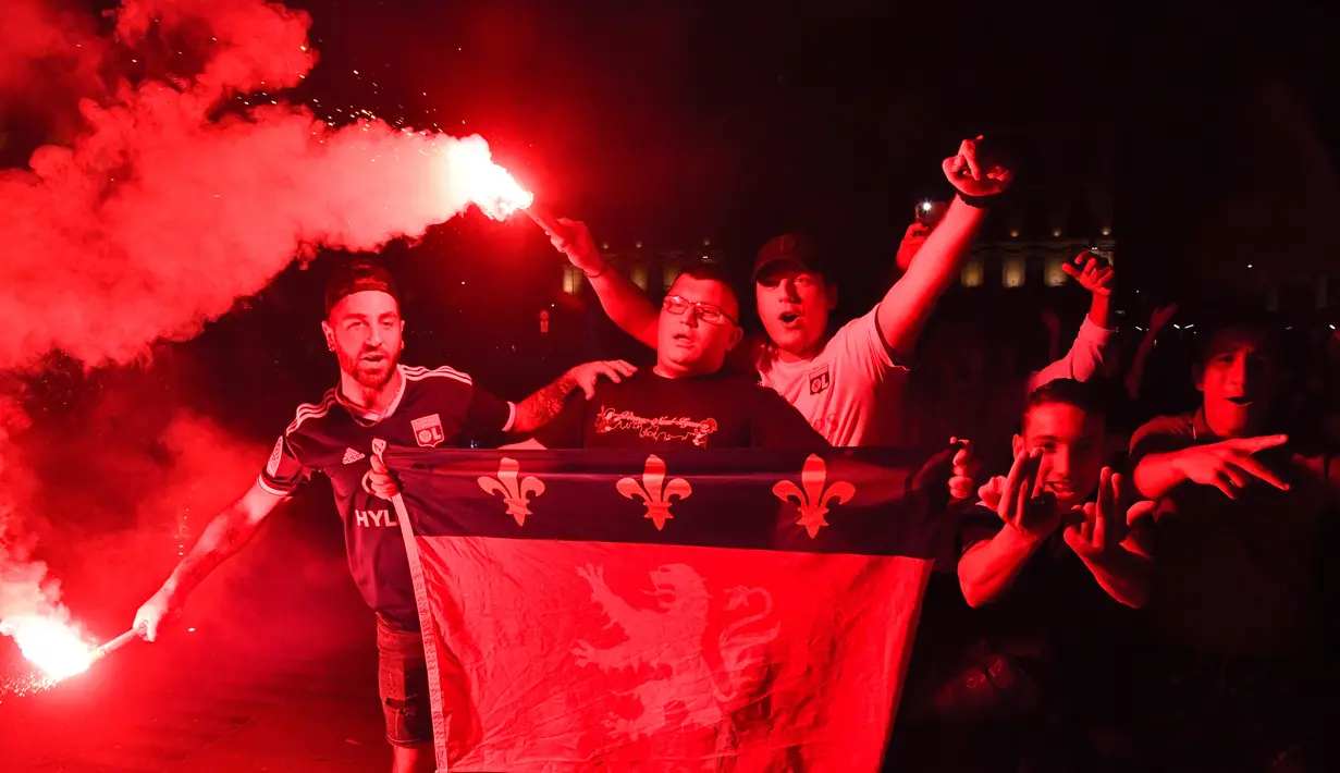 Suporter Lyon membakar suar dan mengibarkan bendera kota setelah tim mereka kalah atas Bayern Munchen pada babak Semifinal Liga Champions di Lyon, Prancis (19/8/2020). Lyon takluk 0-3 atas Munchen di stadion Jose Alvalade di Lisbon, Portugal. (AFP Photo/Filippe Desmazes)