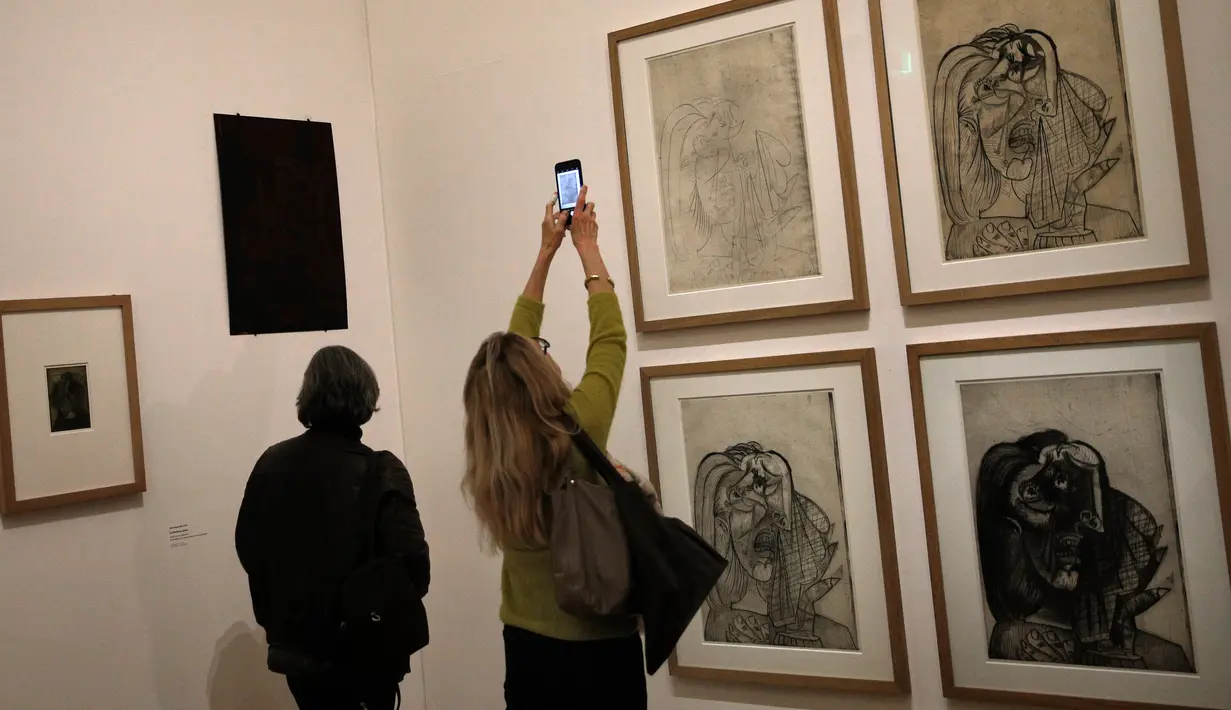 Pengunjung mengambil gambar lukisan-lukisan karya Pablo Picasso dalam pameran 'Guernica' di Museum Picasso, Paris, Prancis, Jumat (23/3). Pameran ini memperingati 80 tahun karya Pablo Picasso. (AP Photo/Christophe Ena)