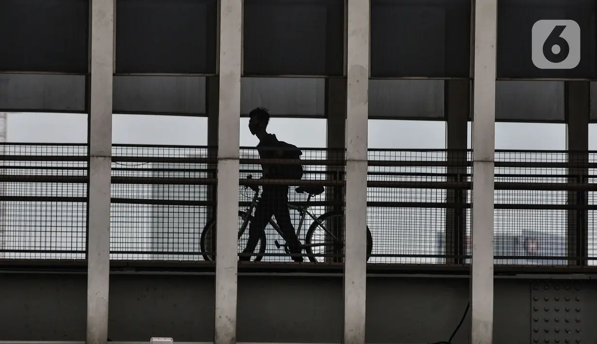 Pengguna sepeda saat melintas jembatan penyeberangan orang di Jalan Jenderal Soedirman, Jakarta, Minggu (11/10/2020). Gubernur DKI Jakarta Anies Baswedan kembali memberlakukan PSBB Transisi selama dua pekan ke depan mulai 12-25 Oktober 2020. (merdeka.com/Iqbal S. Nugroho)