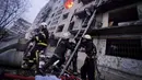 Petugas pemadam kebakaran berusaha mengevakuasi warga dari gedung apartemen yang terkena tembakan di Kyiv, Ukraina (14/3/2022). Dua orang tewas pada 14 Maret 2022 akibat serangan penembakan dan rudal Rusia yang menghancurkan gedung apartemen tersebut. (Ukrainian State Emergency Service via AP)
