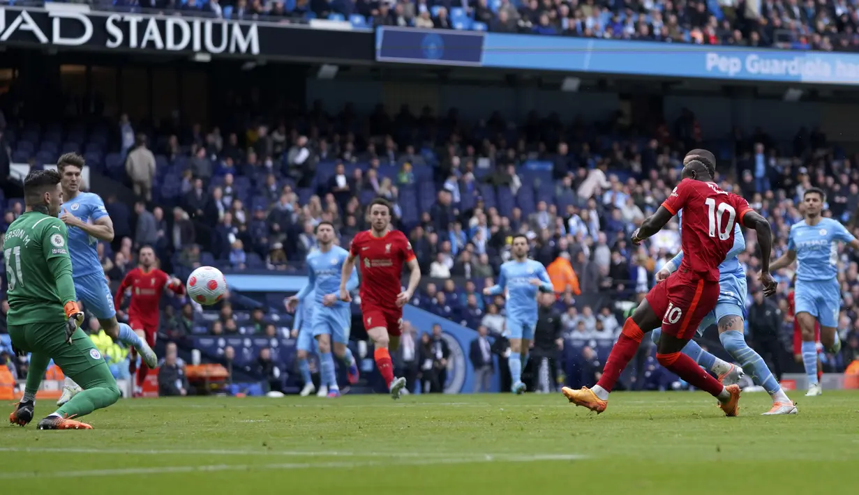 Pemain Liverpool Sadio Mane (kanan) mencetak gol ke gawang Manchester City pada pertandingan sepak bola Liga Inggris di Etihad Stadium, Manchester, Inggris, 10 April 2022. Laga berakhir imbang 2-2. (AP Photo/Jon Super)