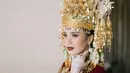 Di momen akad nikah, Beby Tsabina memilih mengenakan baju pengantin adat Aceh berwarna merah. Warna merah bertemu dengan berbagai bordir, payet, dan aksesori emas yang menambah nuansa mewah pada keseluruhan penampilannya. [Foto: Instagram/bebytsabina]