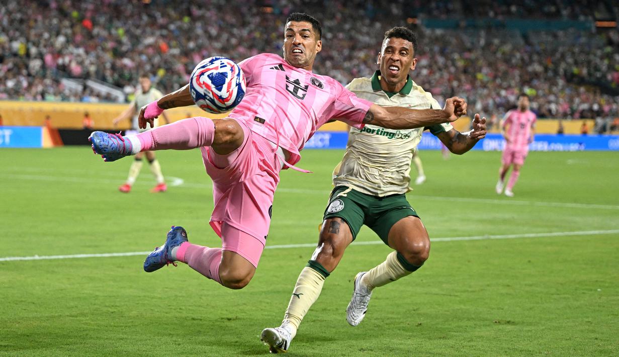 Pemain Inter Miami, Luis Suarez (kiri) berebut bola dengan pemain Palmeiras, Marcos Rocha dalam laga Grup A Piala Dunia Antarklub 2025 di Hard Rock stadium, Miami, Amerika Serikat, Selasa (24/06/2025) WIB. (AFP/Patricia De Melo Moreira)