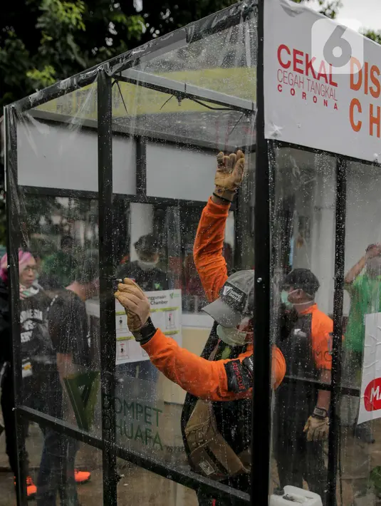 Petugas memasang ruang khusus semprot Desinfektan Chamber di depan Pasar Raya Blok M, Jakarta, Selasa (24/3/2020). Pamasangan ruang khusus semprot Desinfektan Chamber untuk mensterilkan full body masyarakat untuk menekan penyebaran Covid-19. (Liputan6.com/Faizal Fanani)