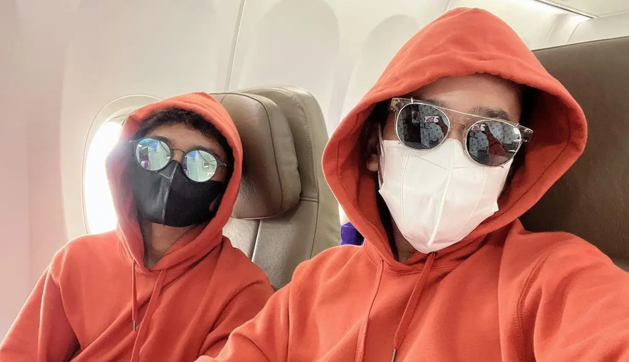 <p>Gaya airport yang nyaman dengan sweater warna orange (Foto: Instagram @ruben_onsu)</p>