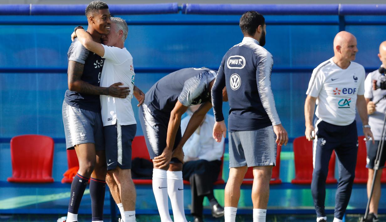 Pelatih Timnas Prancis, Didier Deschamps memeluk Presnel Kimpembe selama sesi latihan tim di Glebovets, Rusia, (12/7). Prancis akan bertanding melawan Kroasia pada babak Final Piala Dunia 2018. (AP Photo / David Vincent)