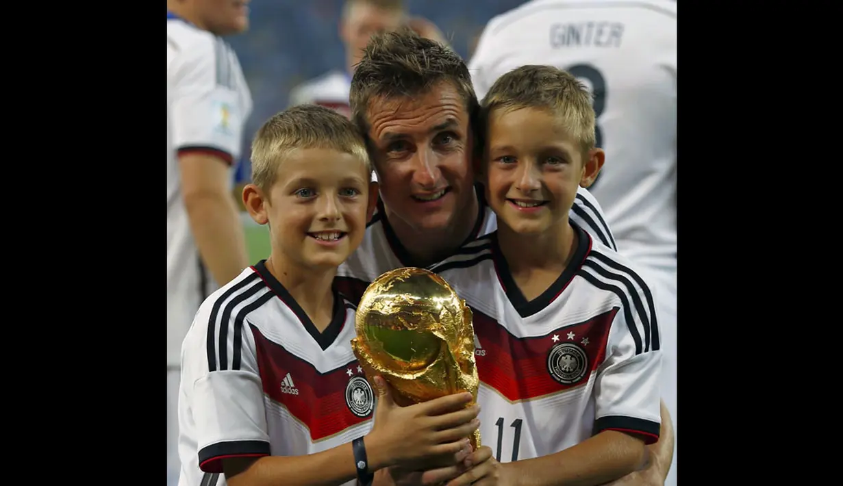 Pemain depan Timnas Jerman, Miroslav Klose (tengah), berpose bersama kedua anaknya usai meraih gelar juara Piala Dunia 2014, Brasil, (14/7/2014). (REUTERS/Eddie Keogh)