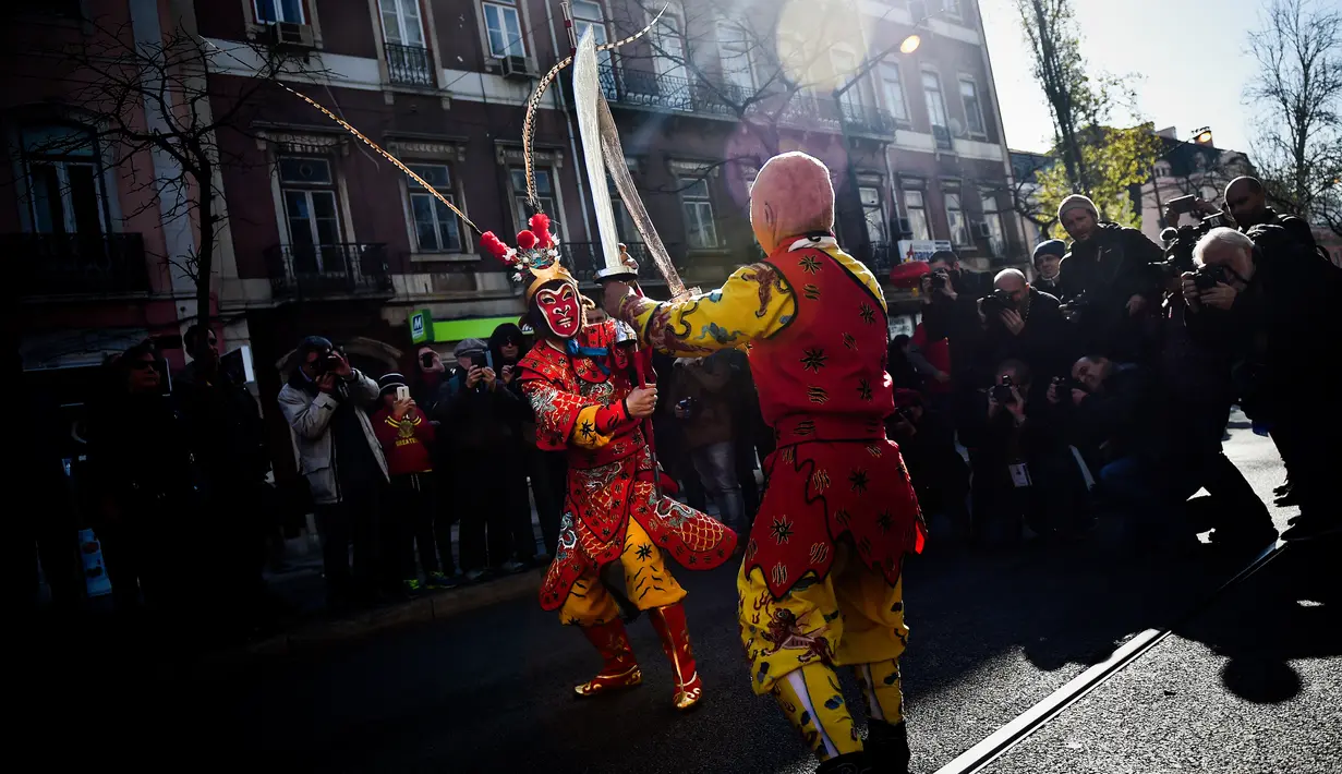 Atraksi saat perayaan menjelang tahun baru China di Lisbon, Portugal (21/1).  Menjelang Imlek, warga keturunan Tionghoa di Portugal juga merayakannya dengan menggelar karnaval di sekitar jalan Kota Lisbon. (AFP/Patricia De Melo Moreira)