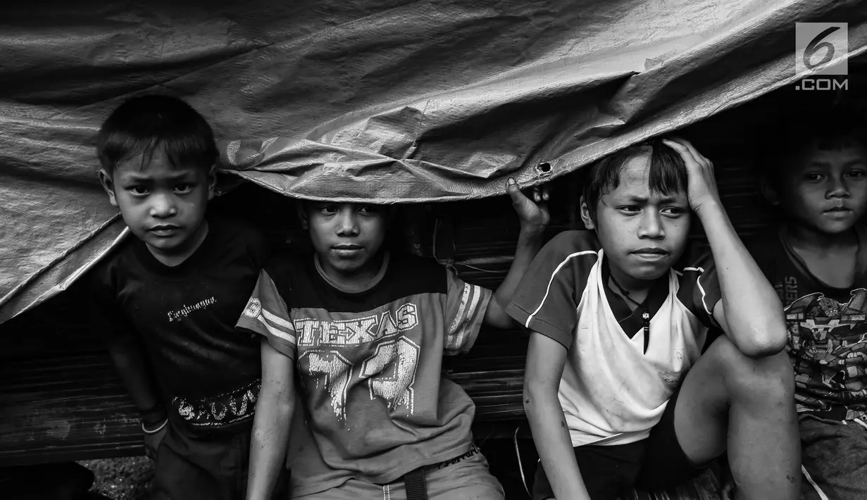 Empat anak Suku Baduy Luar duduk di dalam tenda di lokasi bekas kebakaran Kampung Cisaban II, Desa Kanekes, Banten, Kamis (01/6). Kebakaran pada pekan lalu yang menghanguskan 83 rumah Suku Baduy Luar. (Liputan6.com/Fery Pradolo)