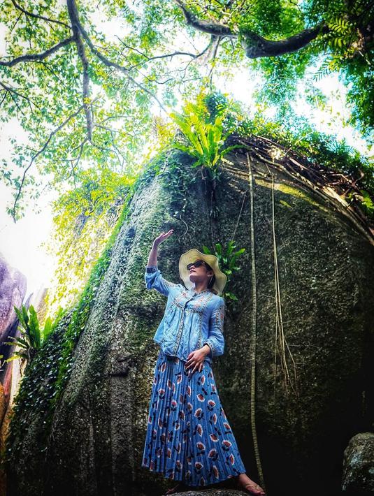 Tak hanya pantai, sisi pantai yang terdapat pemandangan alam indah juga tak luput dijelajahi oleh Dine. Gaya kecenya pakai baju biru ini tuai atensi. Ia juga pakai topi dan kacamata yang bikin dirinya tambah kece. (Liputan6.com/IG/dine.pearl)
