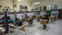 Siswa mengikuti pembelajaran tatap muka (PTM) di sebuah sekolah di Surabaya, Jawa Timur, Senin (6/9/2021). Pemerintah kembali membuka sekolah di tengah pandemi COVID-19. (JUNI KRISWANTO/AFP)