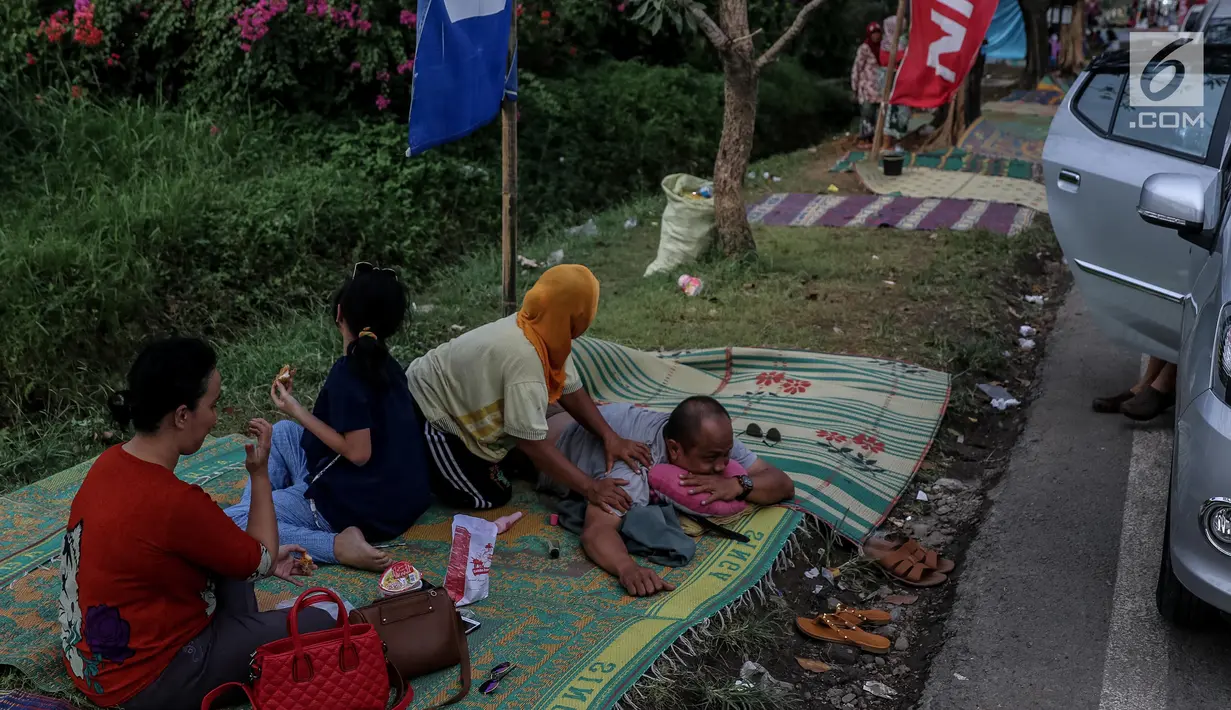 Pemudik memanfaatkan jasa terapis pijat dadakan dari warga sekitar di rest area Tol Palimanan - Kanci, Cirebon, Jawa Barat, Sabtu (1/7). Selama lebaran warga sekitar memanfaatkan arus balik dengan menyediakan jasa pijat. (Liputan6.com/Faizal Fanani)