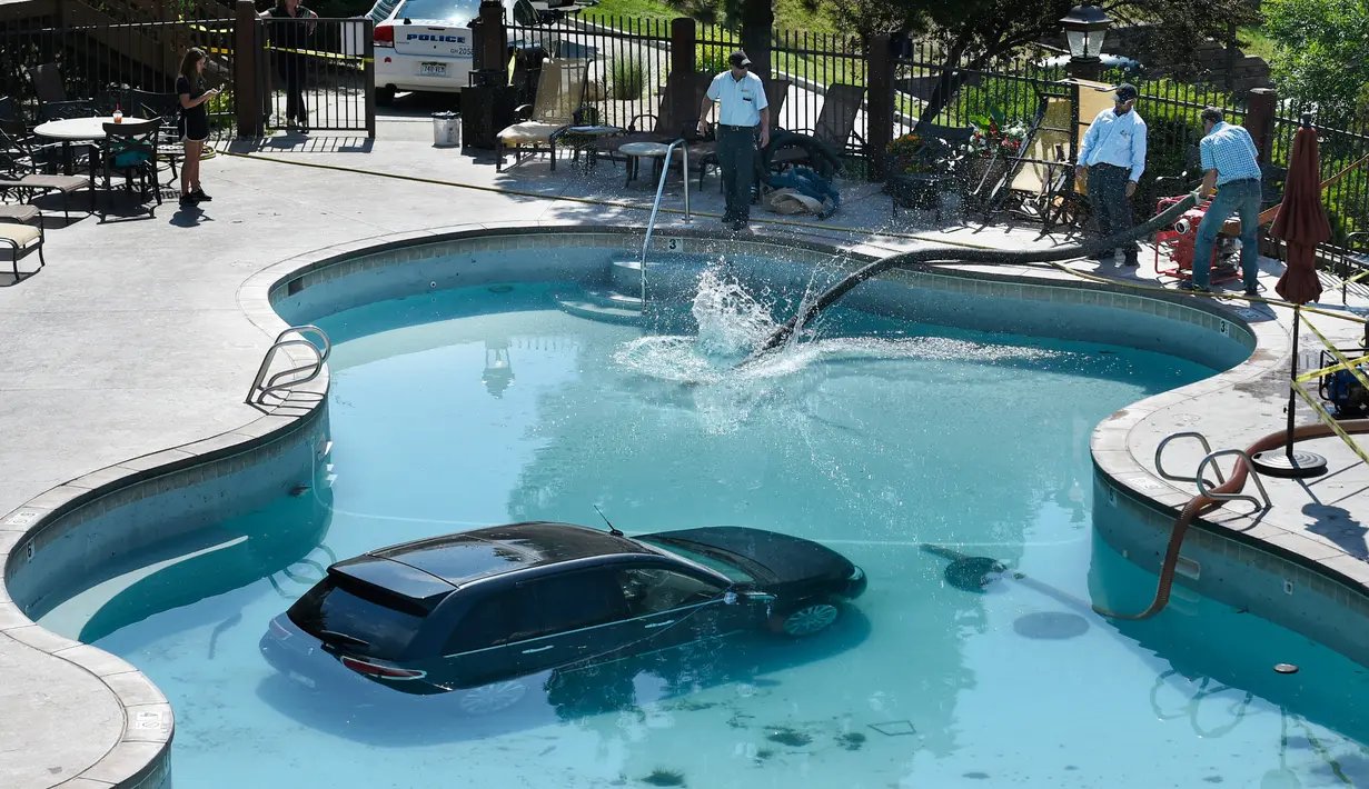Pekerja menyedot air setelah sebuah mobil masuk ke kolam renang di Cheyenne Mountain Resort, Colorado Springs, (4/7). (Jerilee Bennett / The Gazette via AP)